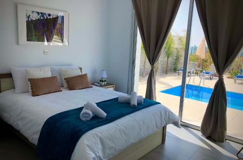 a bedroom with a large bed with towels on it at Sophia's Seaview Luxury Villas in Paphos City