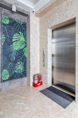 a elevator lobby with a large metal door with a painting at Meets Anping in Tainan