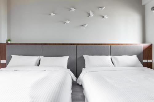 two beds sitting next to each other in a room at Meets Anping in Tainan