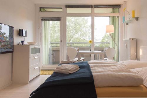 Schlafzimmer mit einem Bett, einem Tisch und einem Fenster in der Unterkunft Ferienwohnung Smaland in Schilksee