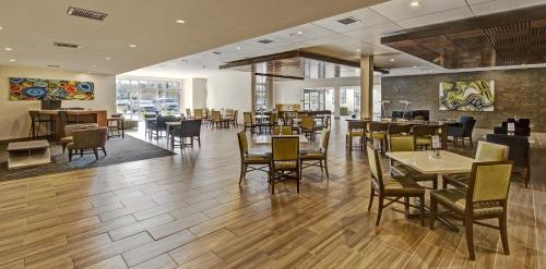 a dining room with tables and chairs in a restaurant at Holiday Inn Express Louisville Airport Expo Center by IHG in Louisville