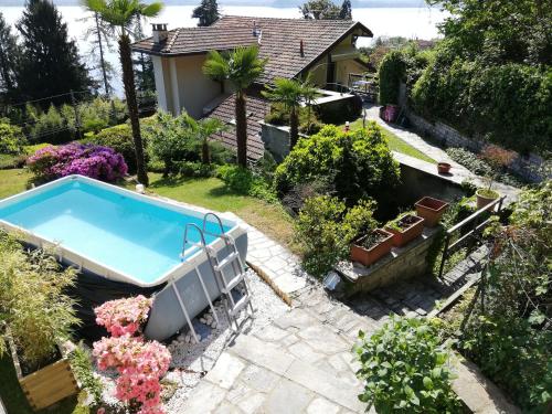 a swimming pool in a garden with flowers at Romantica casetta nel verde con vista sul lago in Belgirate