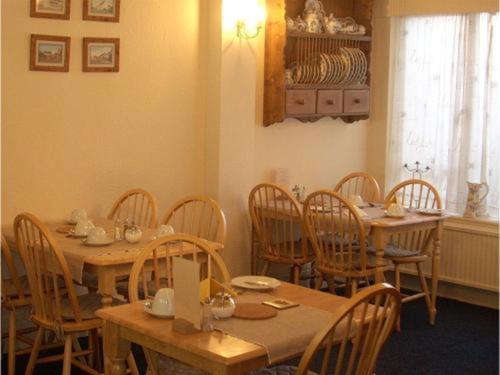 a dining room with wooden tables and chairs at The Adelphi in Paignton