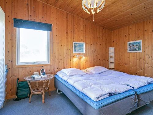 Un dormitorio con una cama y una mesa. en Holiday home Løkken XLVII, en Løkken