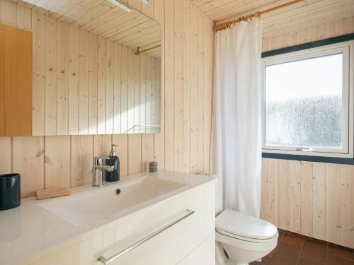 baño con aseo y lavabo y ventana en Holiday home Løkken XLVII, en Løkken