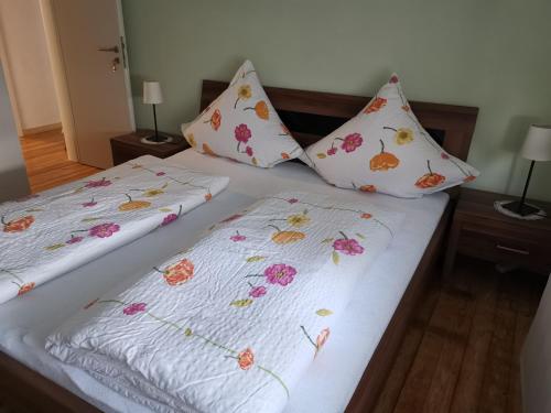 two beds with white sheets with flowers on them at Seppl in Bremm