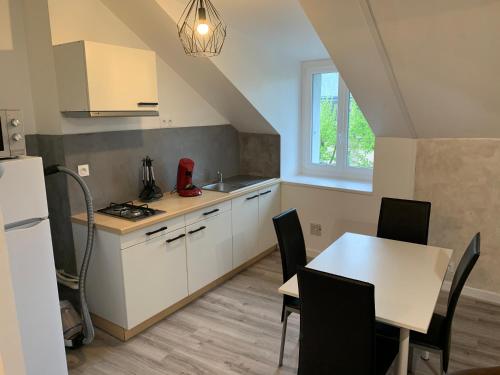 une cuisine et une salle à manger avec une table et des chaises dans l'établissement Rue de la banque centre ville Rodez, à Rodez
