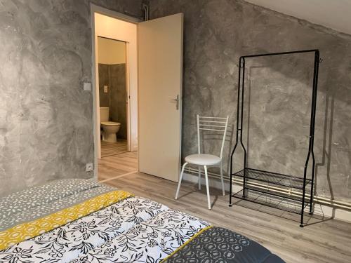 een slaapkamer met een bed en een stoel erin bij Rue de la banque centre ville Rodez in Rodez