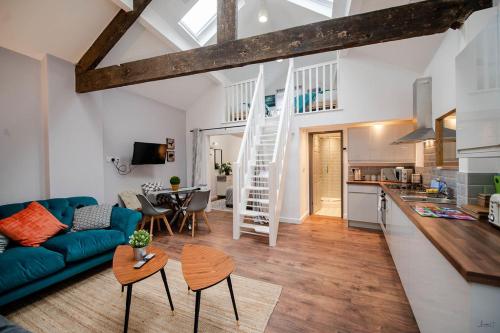 uma sala de estar com um sofá azul e uma cozinha em Apartment 2 Broadhurst Court sleeps 6, minutes from town centre & trains em Stockport