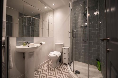 a bathroom with a sink and a toilet and a shower at Air Host and Stay - Apartment 5 Broadhurst Court sleeps 6 minutes from town centre in Stockport