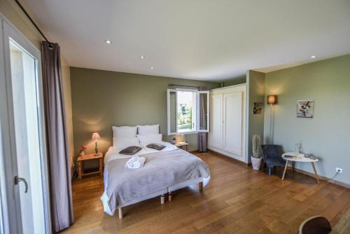 a bedroom with a large bed and a window at La Grande Oasis - B&B et Spa in Grazac
