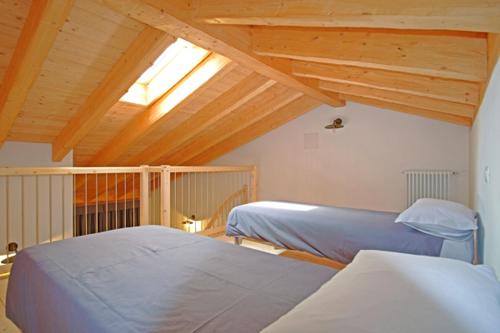 two beds in a room with a attic at Adda Vegia in Buglio in Monte