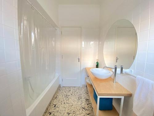 W łazience znajduje się umywalka, wanna i lustro. w obiekcie Casa dos Limões w mieście Bombarral