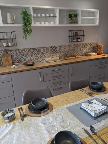 a kitchen with a table with plates and glasses on it at Gite de Fleurie - Tursac in Tursac