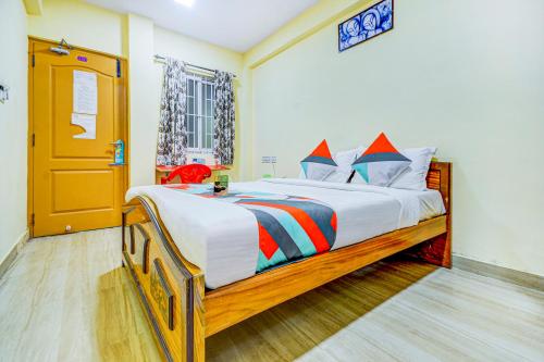 a bedroom with a large bed with a wooden frame at FabExpress Ragu Residency in Coimbatore