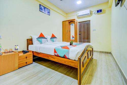 a bedroom with a large bed and a dresser at FabExpress Ragu Residency in Coimbatore
