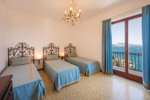 een hotelkamer met twee bedden en een balkon bij VILLA SOLEIL in Massa Lubrense