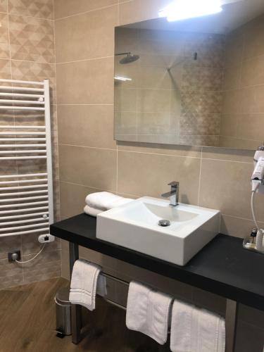 y baño con lavabo blanco y espejo. en Logis Hotels - Hotel Restaurant l Enclos, en Donneville