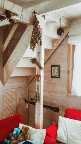 a living room with a red couch and a wooden ceiling at LELE-LAKE super domek Mazury in Pasym