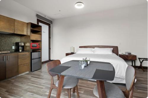 a bedroom with a bed and a table with chairs at Suite Loft Moderno Ubicación Inmejorable 104A in Querétaro