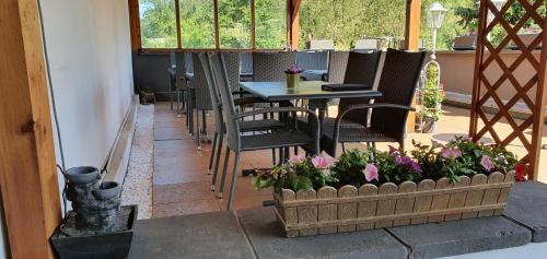eine Terrasse mit einem Tisch, Stühlen und Blumen in der Unterkunft Hotel Zum Deutschen Eck in Velbert
