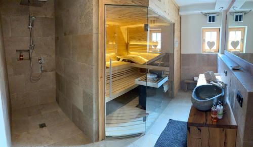 ein Badezimmer mit einer Dusche, einem Waschbecken und einer Badewanne in der Unterkunft BERGSUCHT-Ruhpolding in Ruhpolding
