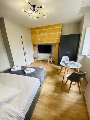 a small room with two beds and a table at Sarlat.Catalina in Sarlat-la-Canéda
