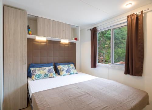 Schlafzimmer mit einem Bett und einem Fenster in der Unterkunft Camping Village Laguna Blu in Fertilia
