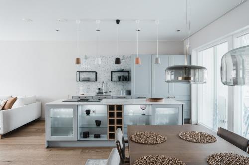 a kitchen with a table and a kitchen island at Luxury Apartment Hovi in Naantali