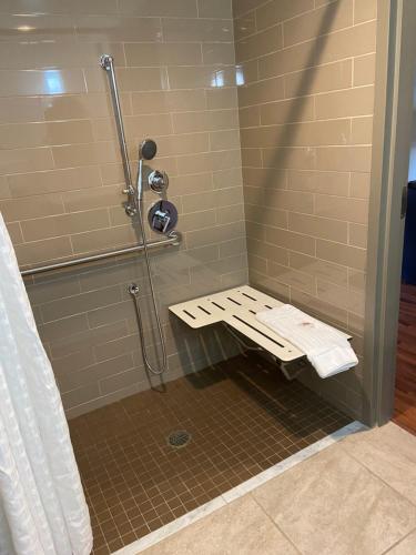 a shower with a bench in a shower stall at Comfort Inn Connellsville Riverview in Connellsville