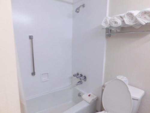 a white bathroom with a toilet and a bath tub at Americas Best Value Inn Winston-Salem in Winston-Salem