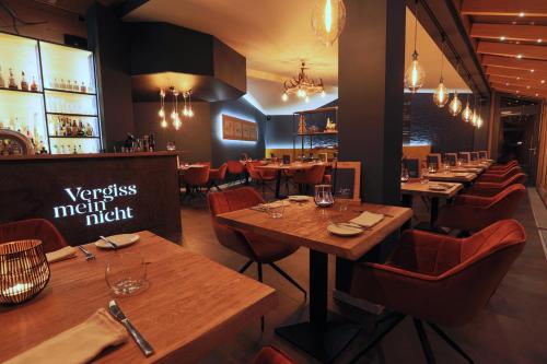 a restaurant with wooden tables and chairs and a bar at Vergissmeinnicht in Oberhof