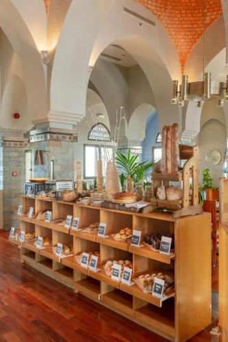 a bakery with shelves filled with different types of bread at The Cove Rotana Resort - Ras Al Khaimah in Ras al Khaimah