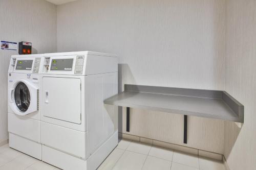 a laundry room with a washer and a washing machine at Holiday Inn Express Rochester-Victor by IHG in Victor