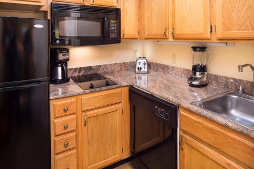 a kitchen with a black refrigerator and a sink at Villas de Santa Fe in Santa Fe