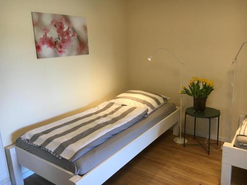 a bed in a room with a plant on a table at Huck’s Ferienhäuser in Borstel