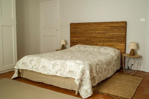 a bedroom with a bed and two lamps and two rugs at Gîte du Café Suquet Giroussens in Giroussens