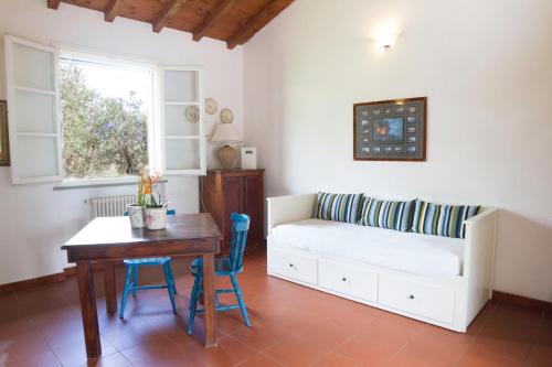 uma sala de estar com um sofá e uma mesa com cadeiras em Fattoria di Collemezzano em Collemezzano