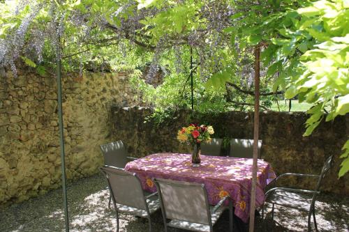 een tafel met een vaas met bloemen erop bij L'Oubradou Mas de charme shared pool in Provence nature and calm in Flayosc