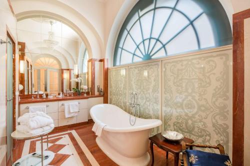 Best Western Plus Hotel StadtPalais في براونشفايغ: حمام مع حوض استحمام و نافذة كبيرة