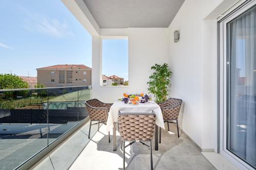 een eetkamer met een tafel en stoelen op een balkon bij Apartmani Laurus in Trogir