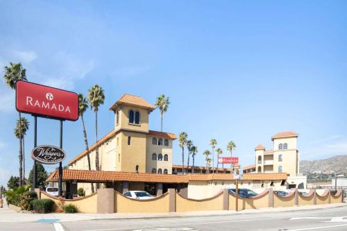 a building with a sign on the side of a street at Ramada by Wyndham Burbank Airport in Burbank
