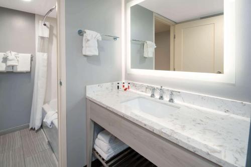 La salle de bains est pourvue d'un lavabo et d'un miroir. dans l'établissement Ramada by Wyndham Burbank Airport, à Burbank