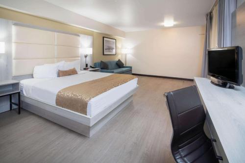 a hotel room with a bed and a television at Ramada by Wyndham Burbank Airport in Burbank
