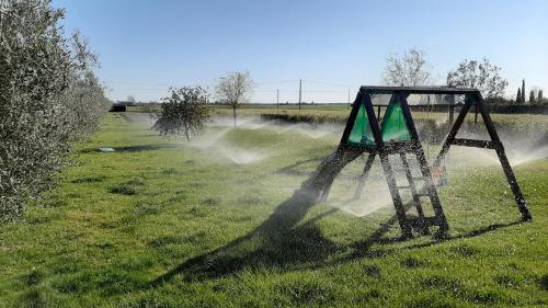 a swing set in a field with water spraying at Agriturismo Corte degli Angeli in Marina di Grosseto