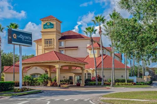 a hotel with a clock tower on top of a building at La Quinta by Wyndham Orlando Airport - On Property Food Trucks & Free Airport Shuttle! in Orlando