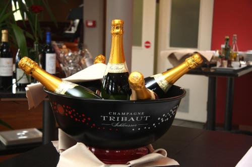 a bucket filled with bottles of wine on a table at Ibis Styles Charleroi Airport Aero 44 in Charleroi