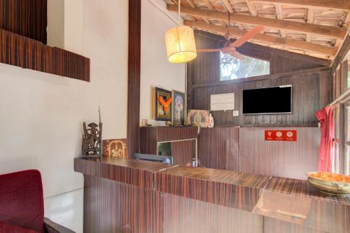 a kitchen with a counter and a tv in a room at Rustic Village - By Rivasa in Calangute