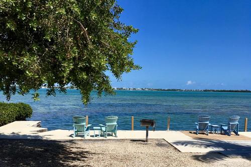 a group of chairs and a grill next to the water at Parmer's Resort in Little Torch Key
