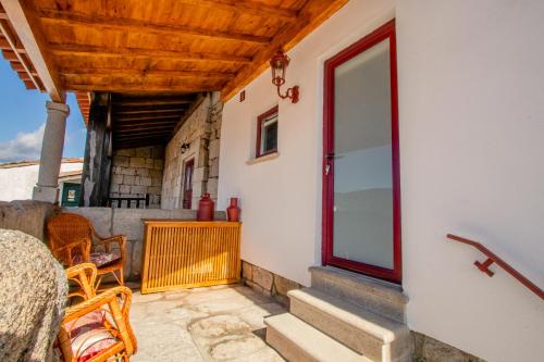 a porch of a house with chairs and a window at Casa do Leão in Marialva